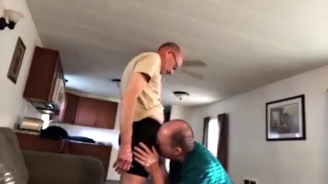Bekleideter Opa kniet und lutscht Papas Schwanz